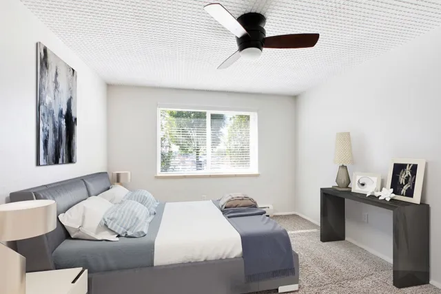 Bright and contemporary bedroom with elegant decor, featuring a comfortable bed, modern ceiling fan, and large window with natural light.