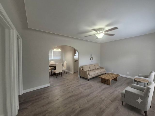 Cozy living and dining area with elegant archway, modern furnishings, and inviting natural light.