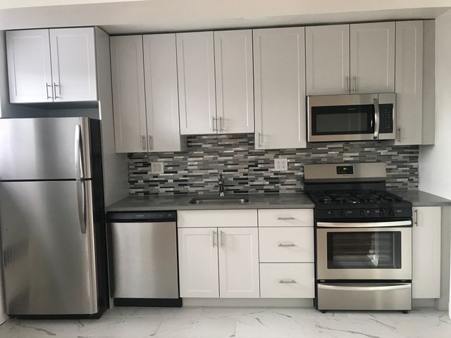 Modern kitchen featuring stainless steel appliances, sleek cabinetry, and a stylish mosaic backsplash.