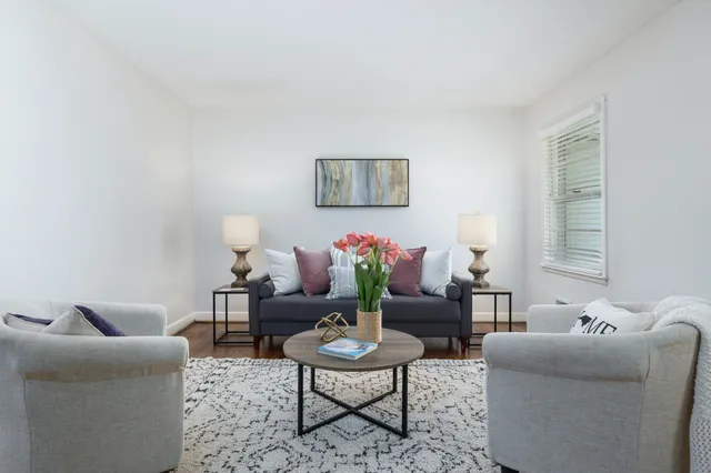 Elegant living room with plush seating, soft cushions, and modern decor featuring a stylish coffee table and vibrant floral arrangement.