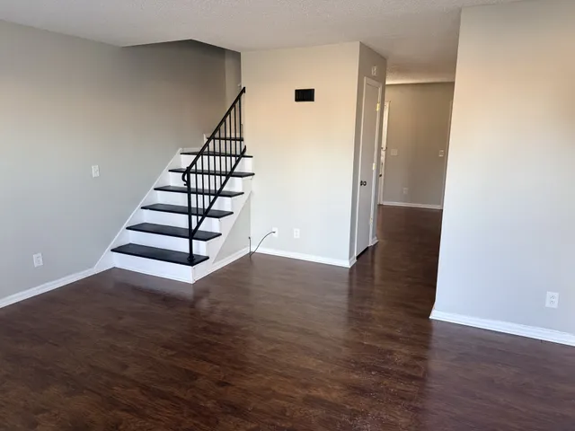 Chic apartment interior featuring sleek wooden floors and a stylish staircase leading to the upper level.
