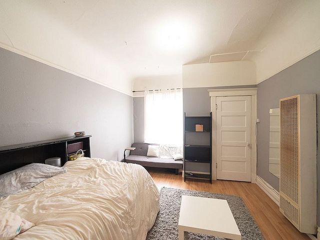Cozy bedroom featuring a soft bed, elegant shelving, and abundant natural light for a tranquil retreat.