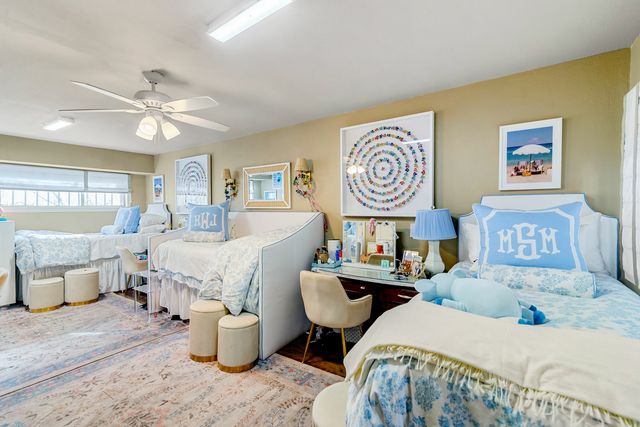 Charming bedroom with twin beds adorned in pastel blue, personalized decor, and a stylish vanity, creating an inviting and cozy atmosphere.