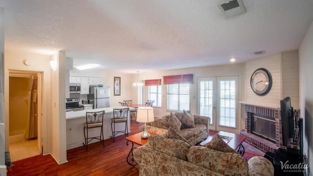 Cozy living room with plush sofas, a warm fireplace, and a modern open kitchen, ideal for relaxed living.