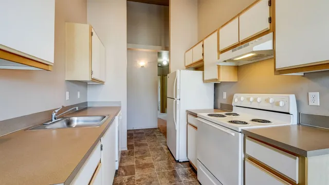 Charming kitchen with modern white appliances, ample cabinetry, and sleek countertops, perfect for culinary adventures.