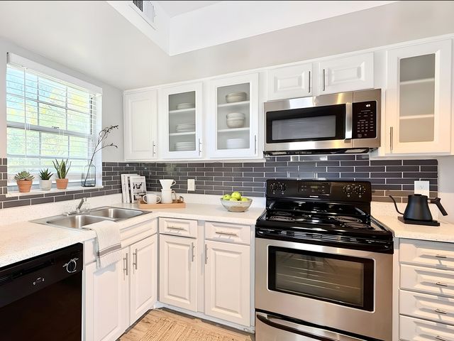 Beautifully designed kitchen with sleek white cabinetry, modern appliances, and ample natural light creating a warm and inviting space.