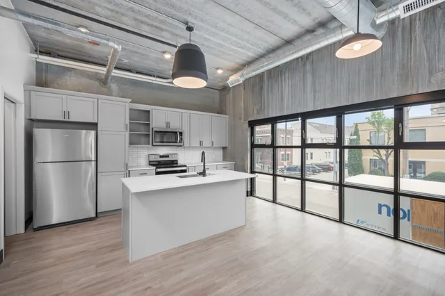 Chic urban kitchen with modern appliances, sleek cabinets, and expansive windows offering abundant natural light.