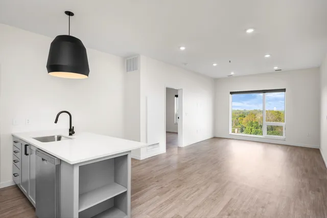 Bright and modern open-concept living space with sleek kitchen island, large windows, and stunning natural views.