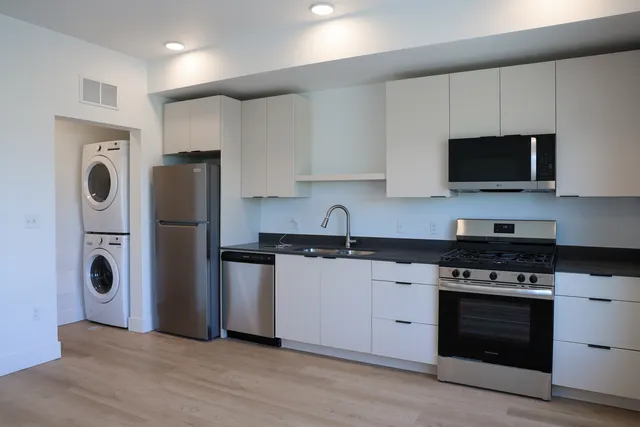 Modern kitchen with sleek cabinetry, stainless steel appliances, and an in-unit washer and dryer, perfect for convenient living.