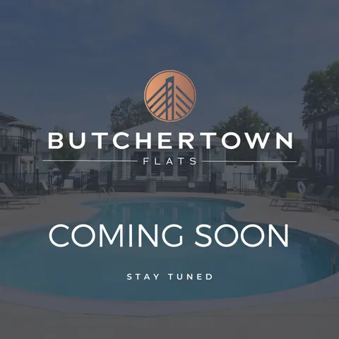 Inviting outdoor pool at Butchertown Flats with modern apartments in the background, labeled \'Coming Soon\'.