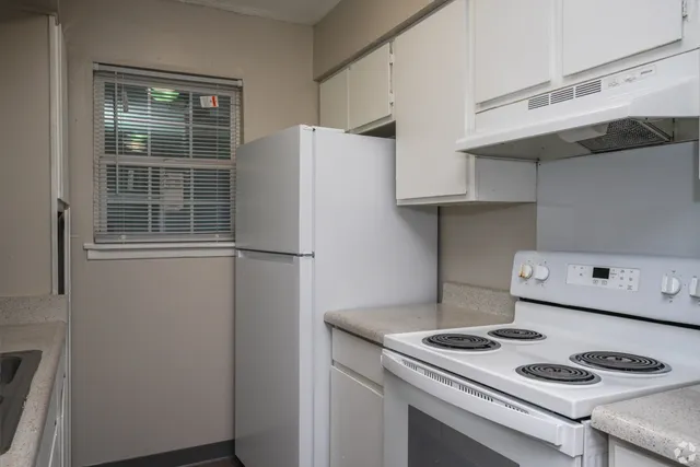 Kitchen with white appliances in 2 bedroom floor plan at Meadow Creek Apartments in Jackson, MS