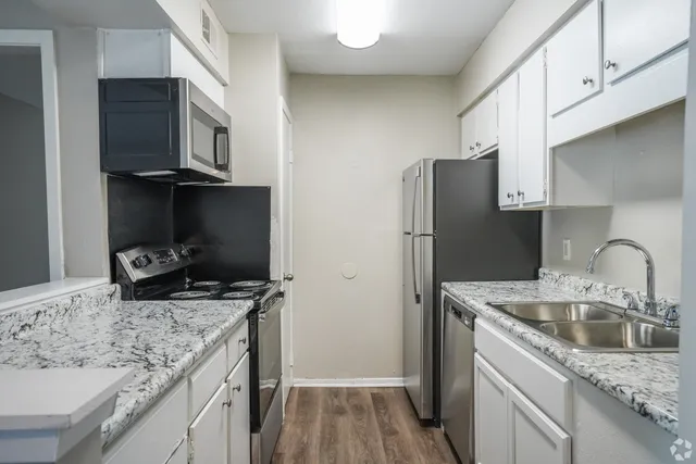 Kitchen with granite counters and black appliances in a 2 bedroom, 2 bath apartment at Trails at Northpointe in Jackson, MS