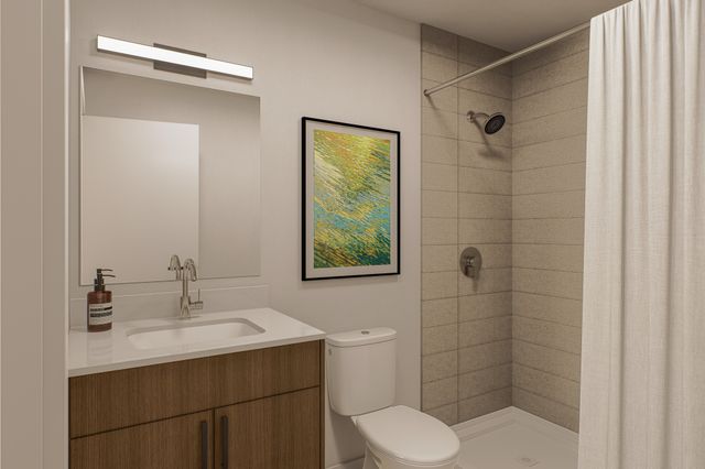 Contemporary bathroom with sleek fixtures, modern shower, elegant mirror, and stylish wall art.