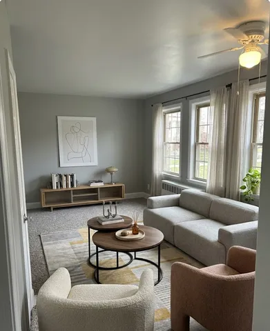 Bright and inviting living room with modern furniture, large windows, and stylish decor in a cozy apartment setting.