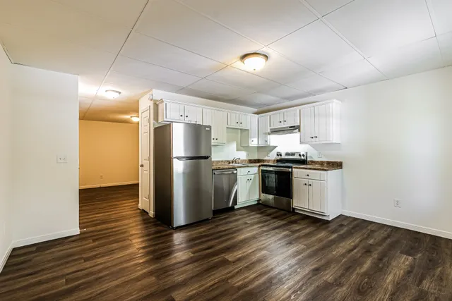 Modern kitchen with stainless steel appliances and elegant wood flooring.
