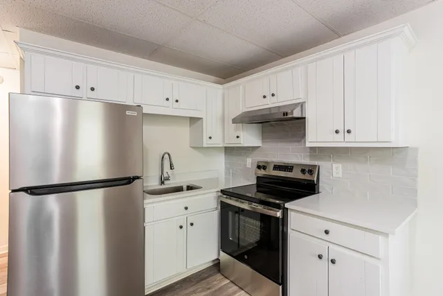 Modern kitchen with sleek stainless steel appliances, elegant white cabinetry, and a stylish backsplash.