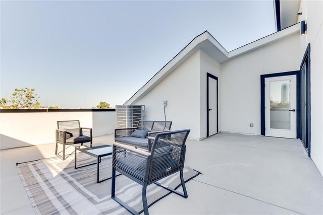 Chic apartment terrace with modern outdoor seating, offering stunning city views and plenty of natural light.