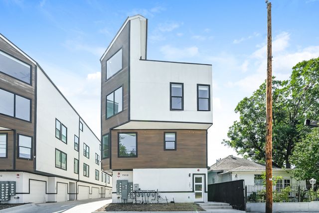 Modern multi-story apartment building with sleek design, large windows, and a stylish wood and white exterior, ideal for urban living.