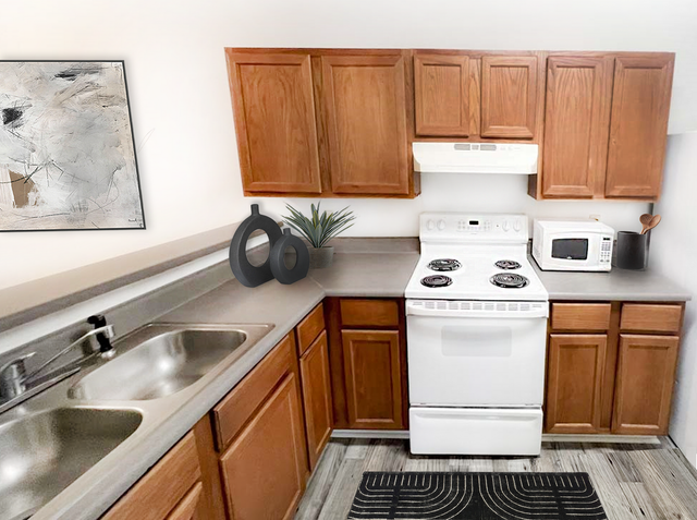 Charming kitchen with wooden cabinets, modern appliances, and sleek countertops, enhanced by elegant decor and contemporary artwork.