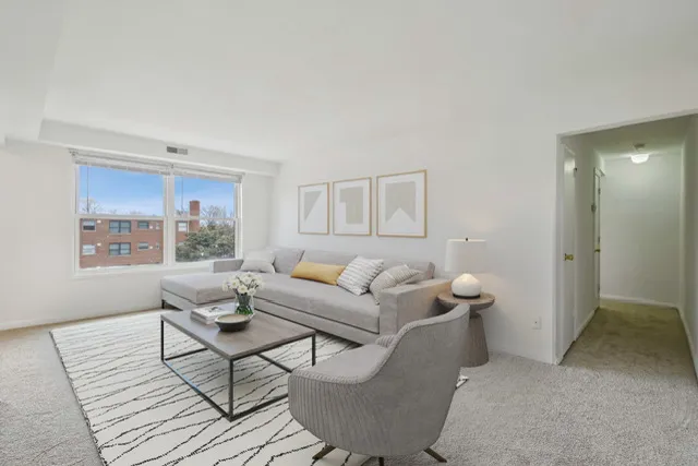 Elegant living room with a large window, modern furniture, and decorative accents.