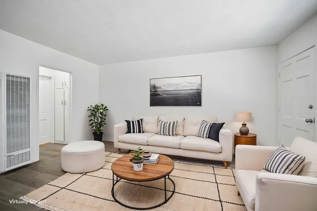 Elegantly staged living room featuring a plush white sofa, modern decor, and a cozy ambiance.