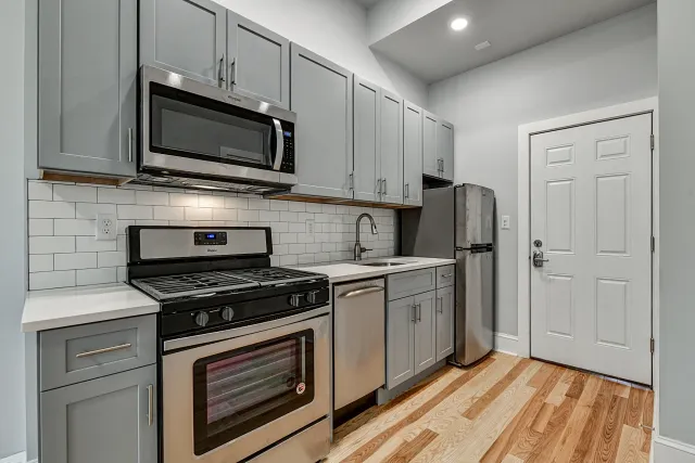 modern updated kitchen with lots of cabinets, range, microwave, dishwasher and stainless steel refrigerator