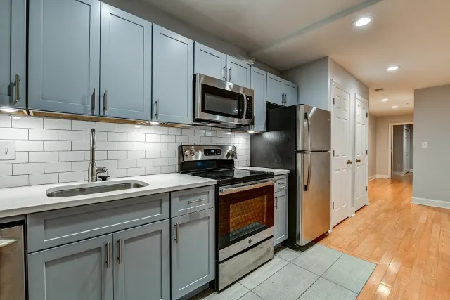 updated kitchen with lots of cabinets, hardwood floors, and stainless steel fridge, range, microwave and diswasher