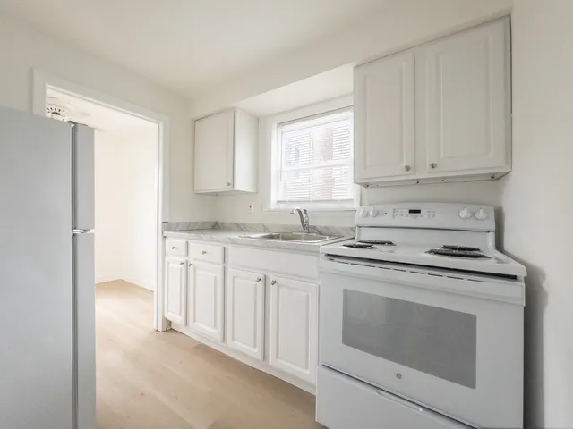 Bright and modern kitchen with sleek white cabinets and a stylish stove, offering a fresh and inviting cooking space.