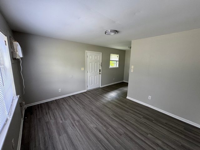 Bright and spacious living area with modern gray flooring and ample natural light, perfect for a comfortable home environment.