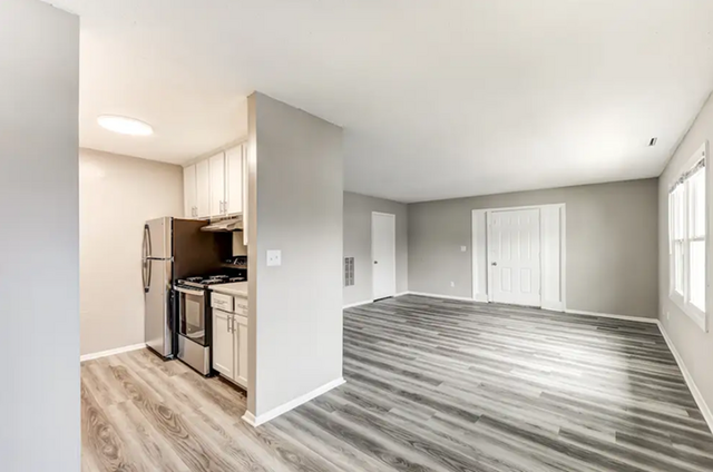 Bright and modern open space with sleek laminate flooring, stylish kitchen, and ample natural light.