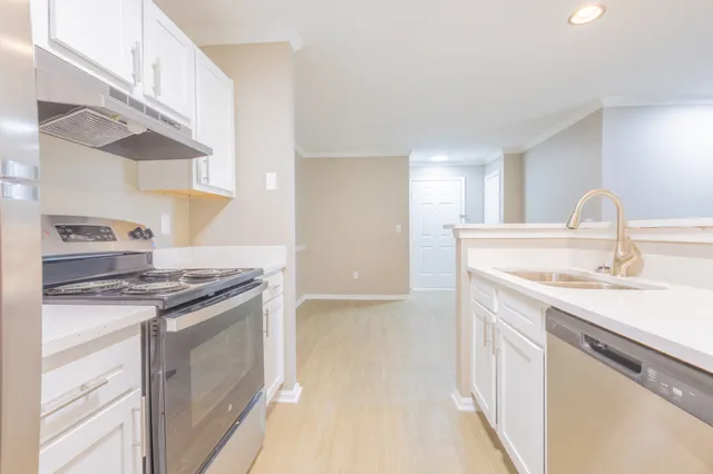 Bright and modern kitchen with sleek appliances, white cabinetry, and inviting open layout.