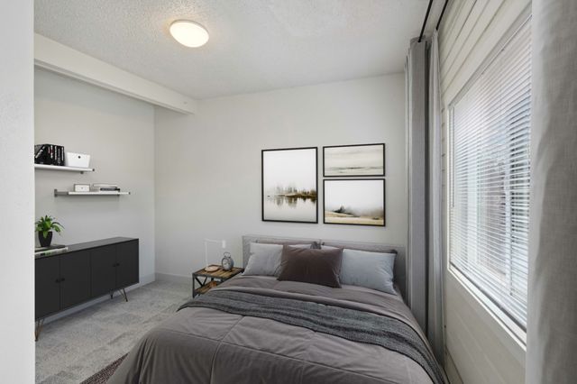 Modern bedroom with sleek decor, featuring a comfortable bed, minimalist shelving, and serene artwork for a cozy atmosphere.