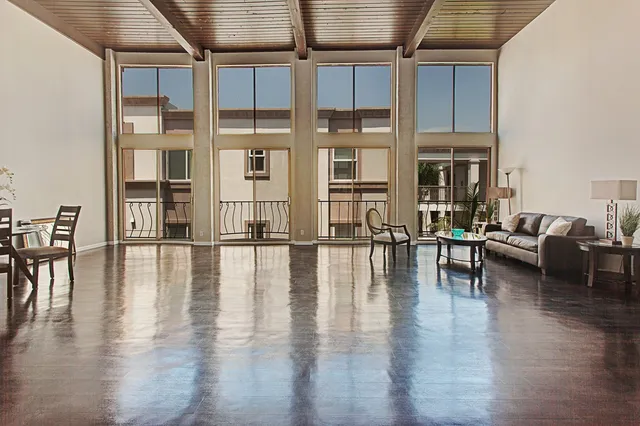 Spacious, elegant living room with high ceilings and expansive floor-to-ceiling windows, offering a bright, open ambiance.
