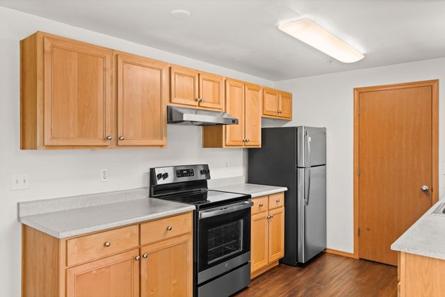 Modern kitchen with wooden cabinets, stainless steel appliances, and sleek countertops.