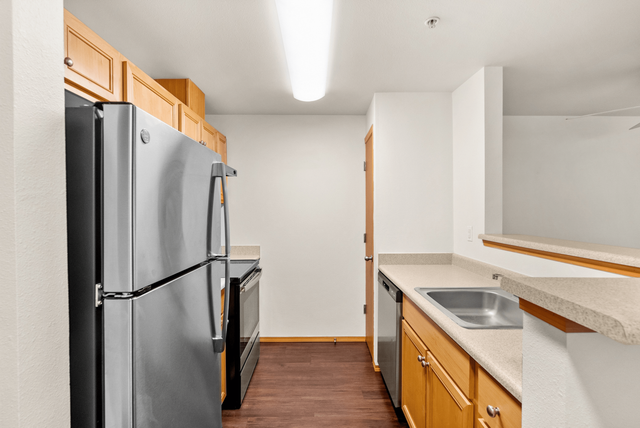 Contemporary kitchen with stainless steel appliances and wooden cabinetry.