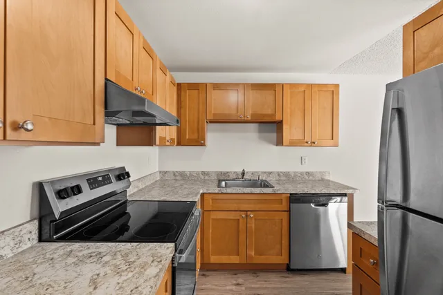 Modern kitchen with sleek stainless steel appliances, elegant wooden cabinetry, and stylish marble countertops.