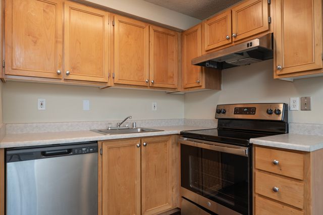 Charming kitchen with warm wood cabinetry, modern appliances, and spacious countertops for culinary creativity.