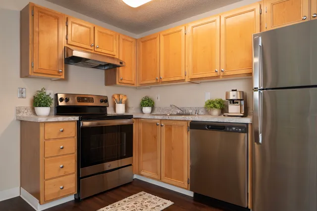 Charming kitchen featuring modern stainless steel appliances, warm wooden cabinets, and elegant marble countertops, perfect for culinary creativity.
