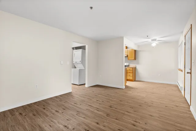Spacious apartment interior with modern laminate flooring, open dining area, and in-unit washer and dryer.
