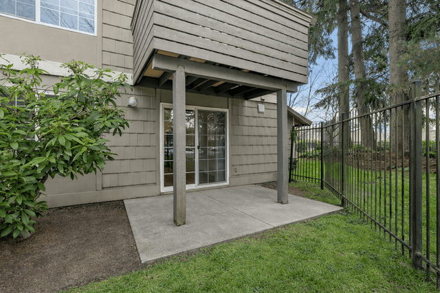 Charming outdoor patio space with lush greenery, ideal for relaxation and alfresco dining.