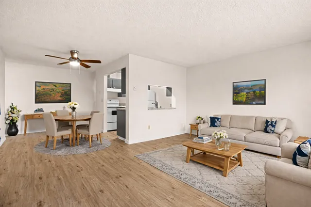 Modern open-concept living and dining area with stylish wooden floors, elegant decor, and a cozy seating arrangement.