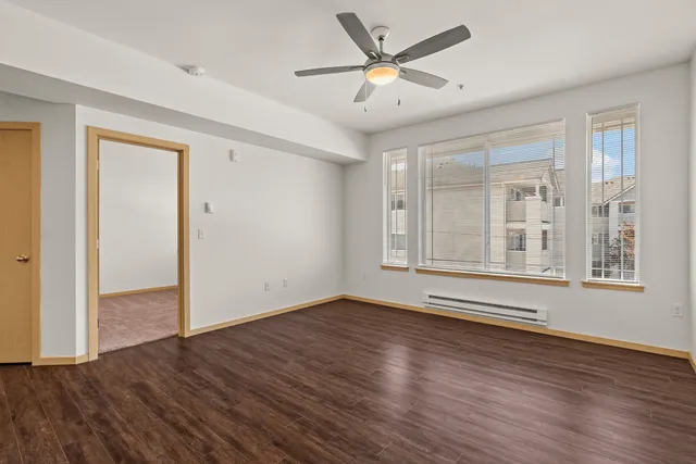 Bright and airy living room with large windows and sleek wood flooring, perfect for a cozy apartment atmosphere.