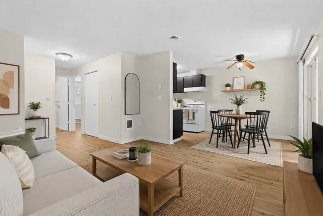 Bright and welcoming open-concept living space highlighting a cozy seating area, modern kitchen, and stylish dining spot.