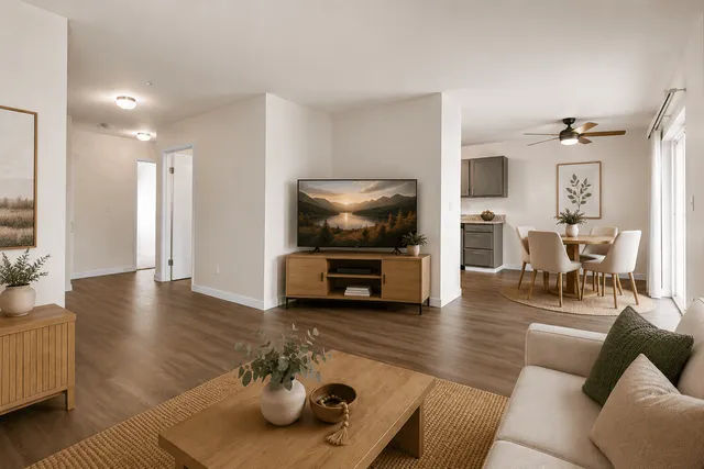 Inviting open-concept living room with elegant hardwood floors, stylish dining area, and modern kitchen.