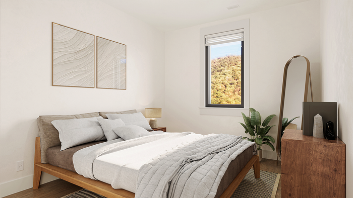 Bright and cozy bedroom with a modern wooden bed, elegant decor, and scenic views through a large window.