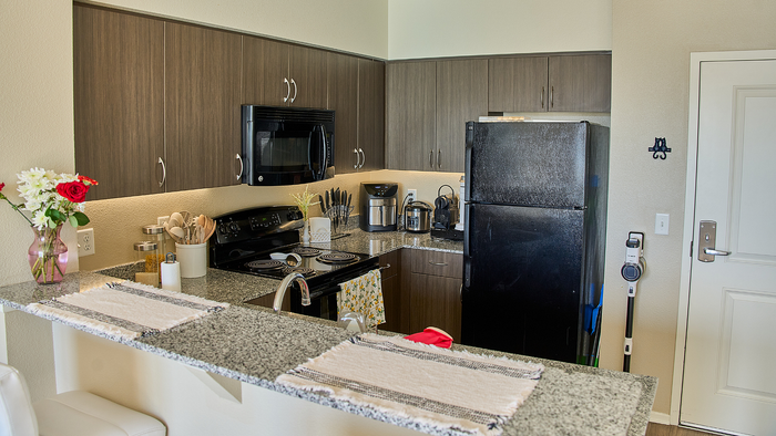 Contemporary kitchen featuring sleek granite countertops, elegant cabinetry, and modern appliances with a charming, compact design.