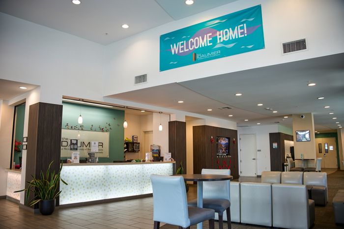 Welcoming modern lobby with stylish seating, vibrant decor, and a 'Welcome Home' banner.