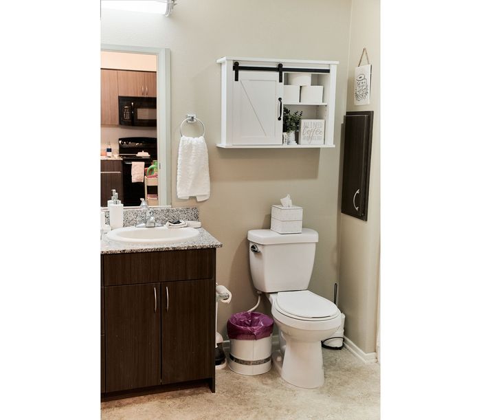 Modern bathroom featuring sleek granite countertops, elegant cabinetry, and stylish wall decor for a cozy touch.