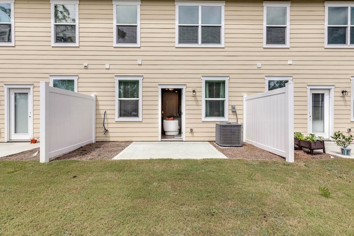 Exterior of back of townhome with patio and privacy fence on two sides