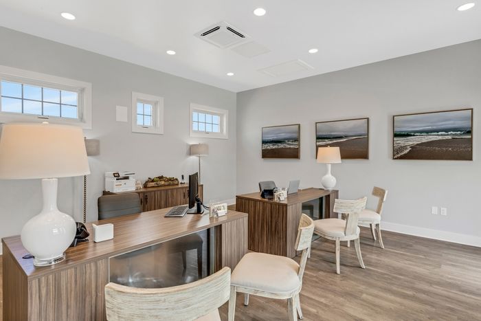 Indoor photo of the leasing office with two desks and art on the wall